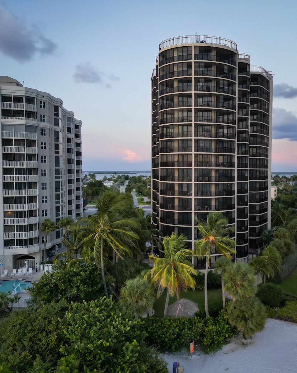 a tall building sitting next to a lush green forest